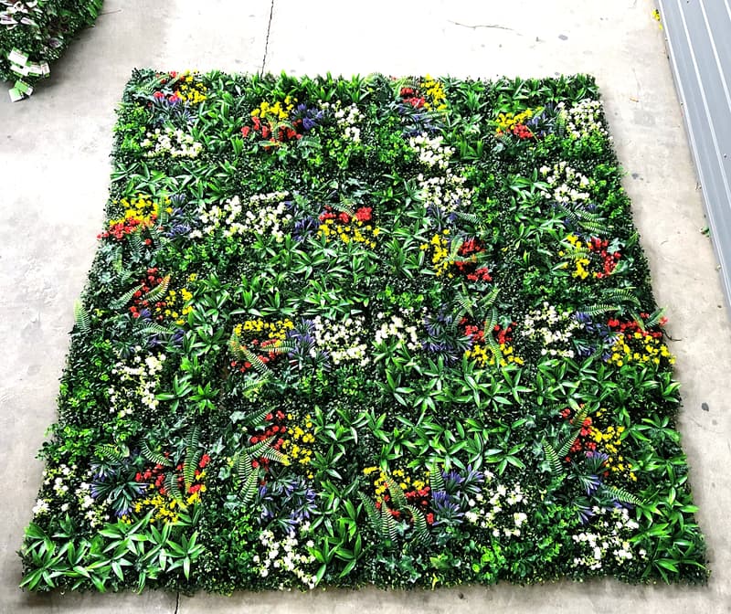 Multiple 20x20 artificial greenery wall panels connected to form a vibrant multi-tone foliage wall with leaf-based color variation