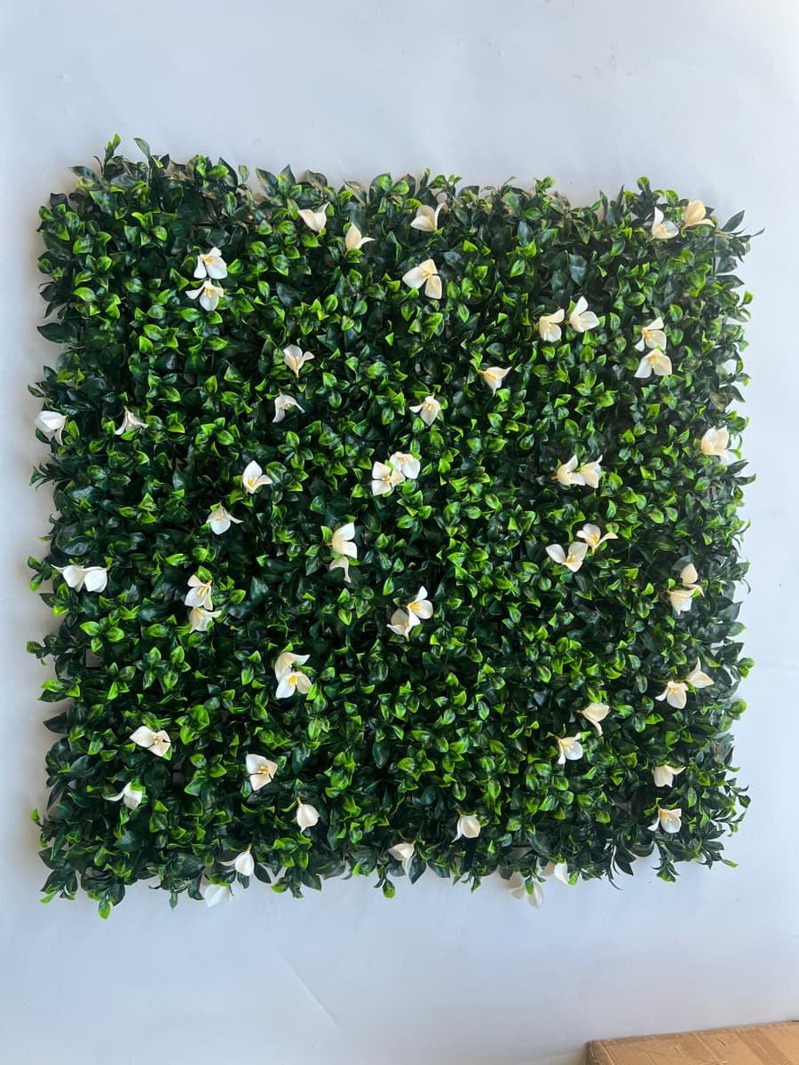 Dense green artificial greenery wall panels used as an elegant backdrop for events and interior feature walls